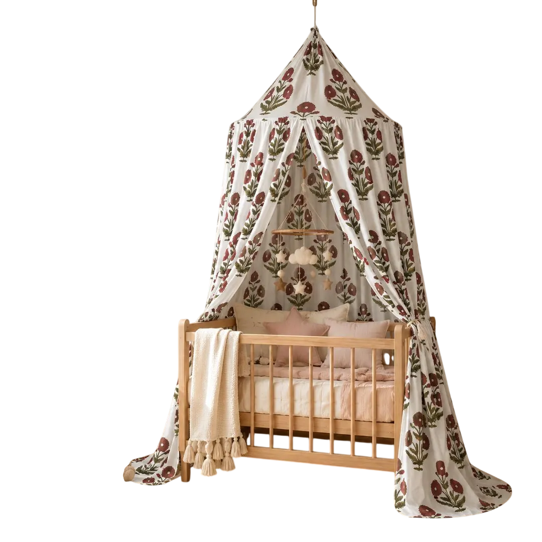 Red floral cotton canopy hanging over a wooden baby crib, featuring hand block printed flowers, gathered panels, cozy nursery decor